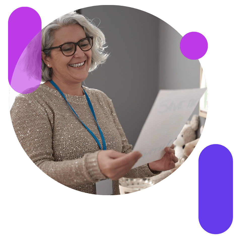 A smiling woman looking at a piece of paper A smiling woman looking at a piece of paper